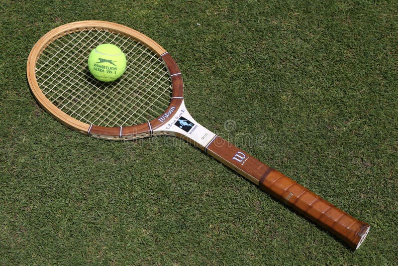 Raquete de tênis de Wilson Cris Evert do vintage e bola de tênis de Slazenger Wimbledon no campo de tênis da grama foto de stock royalty free Raquete de tênis de Wilson Cris Evert do vintage e bola de tênis de Slazenger Wimbledon no campo de tênis da grama foto de stock royalty free