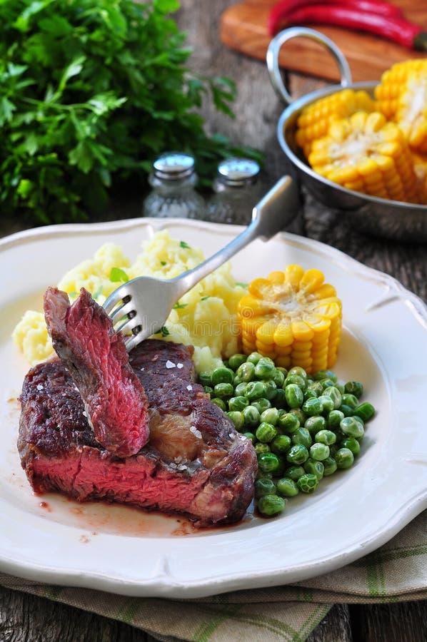 Rare Beef Steak with Mashed Potatoes, Green Peas and Boiled Corn Stock Image Image of olive