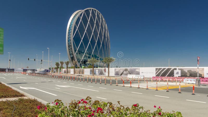 Rascacielos circular aldar cuartel general de construcción de timelapse hyperlapse en abu dhabi uae. tráfico por carretera. es el primer edificio circular de este tipo en el medio oriente.