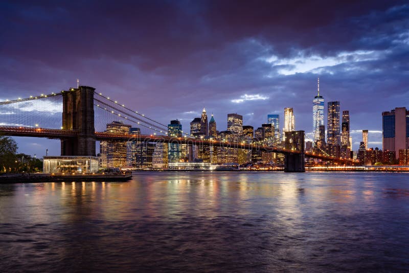 Rascacielos del puente y del Lower Manhattan de Brooklyn en la oscuridad con el East River Manhattan, New York City foto de archivo Rascacielos del puente y del Lower Manhattan de Brooklyn en la oscuridad con el East River Manhattan, New York City foto de archivo
