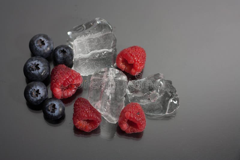 Raspberries and blueberries on black background stock images Raspberries and blueberries on black background stock images