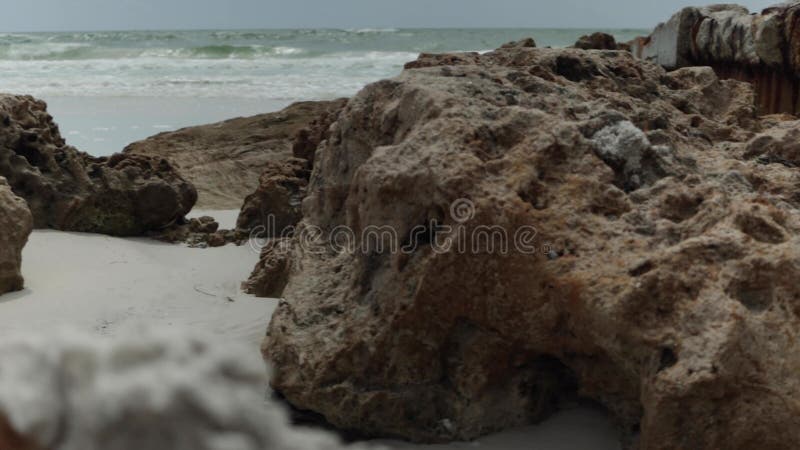 Rastreamento através de rochas marinhas com ondas oceânicas caindo ao fundo