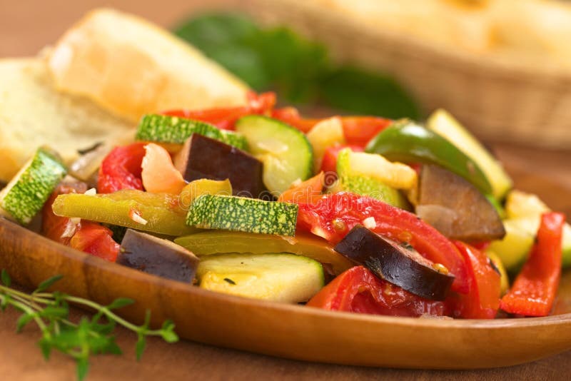 Ratatouille. Fresh homemade Ratatouille made of eggplant, zucchini, bell pepper and tomato and seasoned with herbs (garlic, thyme, oregano) on wooden plate with stock images Ratatouille. Fresh homemade Ratatouille made of eggplant, zucchini, bell pepper and tomato and seasoned with herbs (garlic, thyme, oregano) on wooden plate with stock images