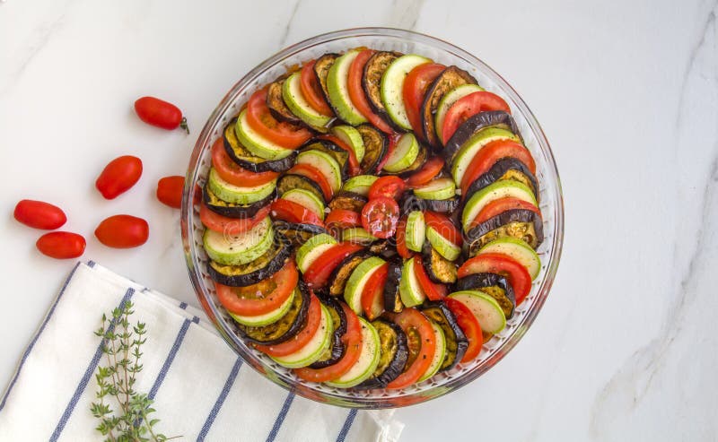 Ratatouille: Färgrika lager av nya sommargrönsaker: zucchini, aubergine, tomater på säsong för tomatsås med vitlök och fres arkivfoto Ratatouille: Färgrika lager av nya sommargrönsaker: zucchini, aubergine, tomater på säsong för tomatsås med vitlök och fres arkivfoto