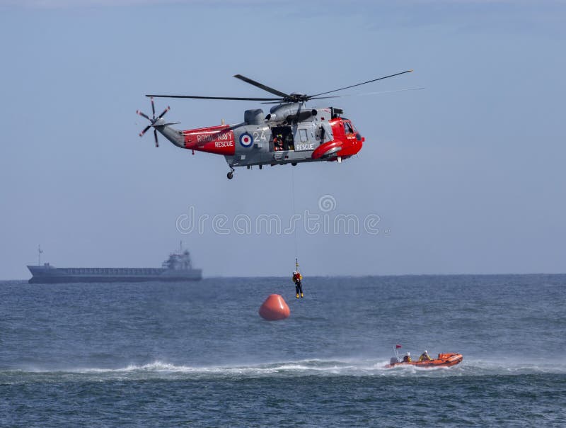 British Royal Navy helicopter and RNLI inshore rescue boat involved in a rescue at sea. British Royal Navy helicopter and RNLI inshore rescue boat involved in a rescue at sea