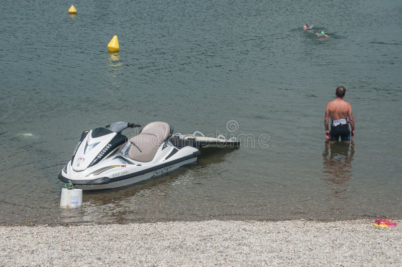 REININGUE - France - 24 June 2017 - lifeguard and jet ski observing in Reiningue lake. REININGUE - France - 24 June 2017 - lifeguard and jet ski observing in Reiningue lake