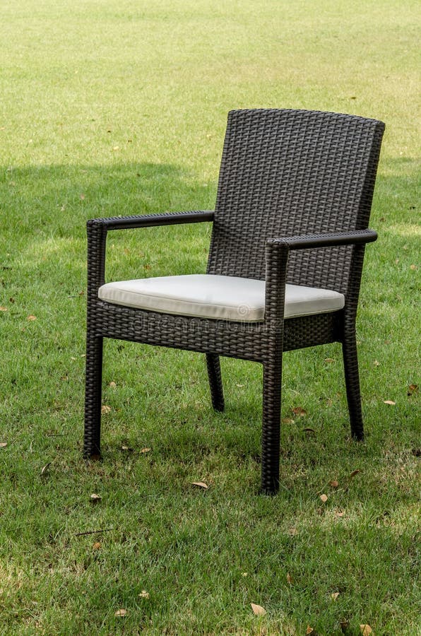 Rattan krzesło z poduszką w ogródzie zdjęcia stock Rattan krzesło z poduszką w ogródzie zdjęcia stock