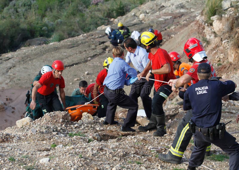 Paramedics secure a litter with a deceased person after crashing in the helicopter the victim was flying. Safety and rescue paramedics prepare to carry the body to local forensics at nearby hospital using a Police Guardia Civil helicopter. Paramedics secure a litter with a deceased person after crashing in the helicopter the victim was flying. Safety and rescue paramedics prepare to carry the body to local forensics at nearby hospital using a Police Guardia Civil helicopter.