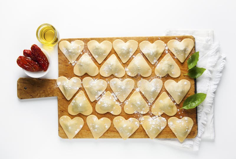 Ravioli in a heart shape. cutting board with a group of raw freshly homemade ravioli . ready to be cooked. food romantic. Ravioli in a heart shape. cutting board with a group of raw freshly homemade ravioli . ready to be cooked. food romantic