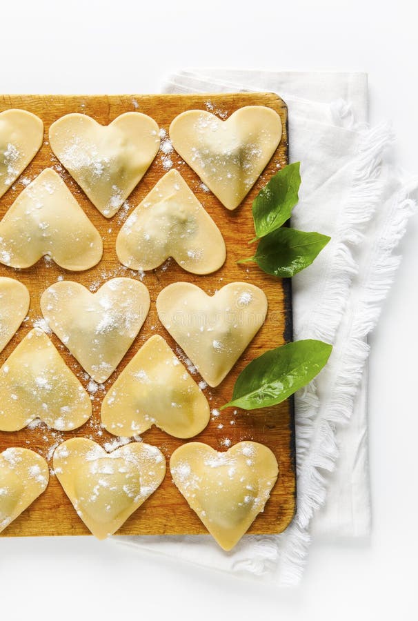 Ravioli in a heart shape. cutting board with a group of raw freshly homemade ravioli . ready to be cooked. food romantic. Ravioli in a heart shape. cutting board with a group of raw freshly homemade ravioli . ready to be cooked. food romantic