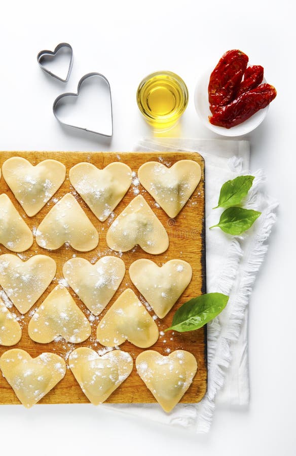 Ravioli in a heart shape. cutting board with a group of raw freshly homemade ravioli . ready to be cooked. food romantic. Ravioli in a heart shape. cutting board with a group of raw freshly homemade ravioli . ready to be cooked. food romantic