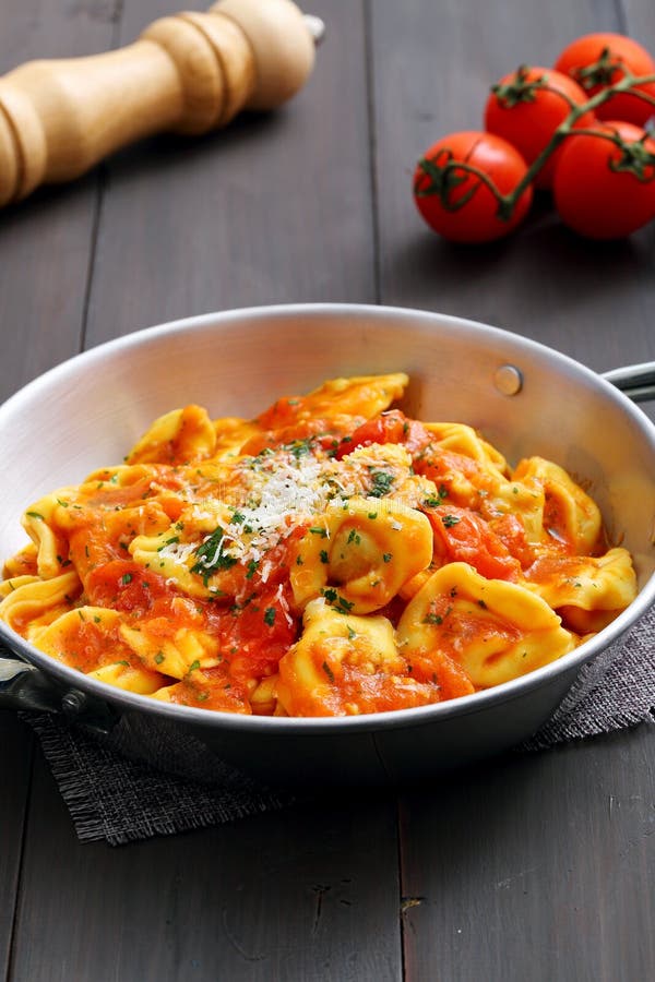 Ravioli met tomatensaus en parmezaanse kaas in metaalkom stock fotografie Ravioli met tomatensaus en parmezaanse kaas in metaalkom stock fotografie