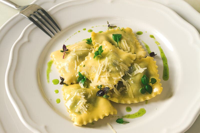 Ravioli with spinach and cheese, green sauce, on a light background, selective focus, no people