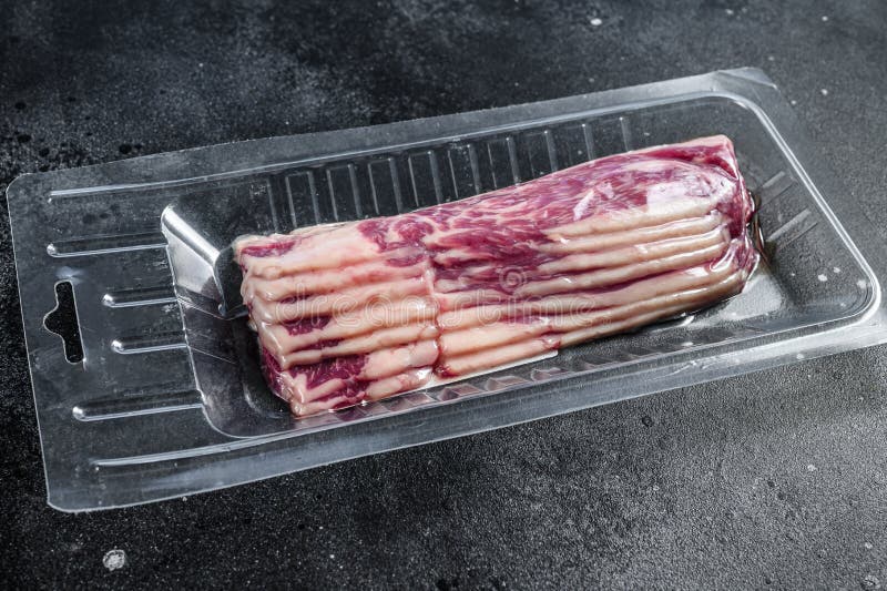 Raw Beef Bacon in Vacuum Packaging. Black Background Stock Image