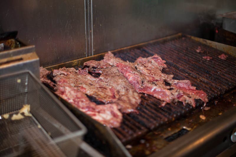 Raw Beef Cooking on an Indoor Grill at a Mexican Restaurant Stock Image