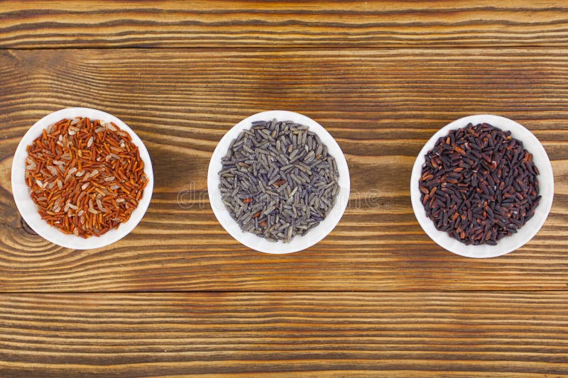 Raw blue rice in bowl on wooden background royalty free stock image