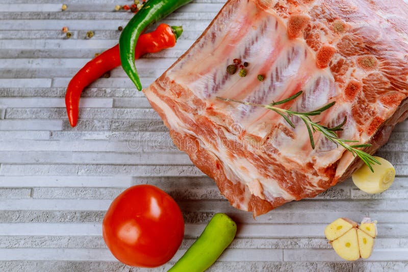 Raw bone-in rib eye pork chops and spices on cutting boards