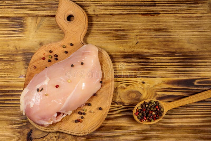 Raw Chicken Breast on Cutting Board on Wooden Table Stock Photo Image