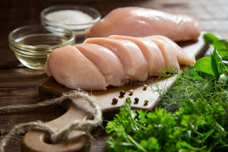 Raw Chicken Breast Fillets and Vegetable on Wooden Cutting Board Stock