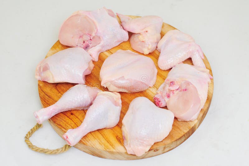 Raw Chicken on a Cutting Board with Garnished Vegetables with a White