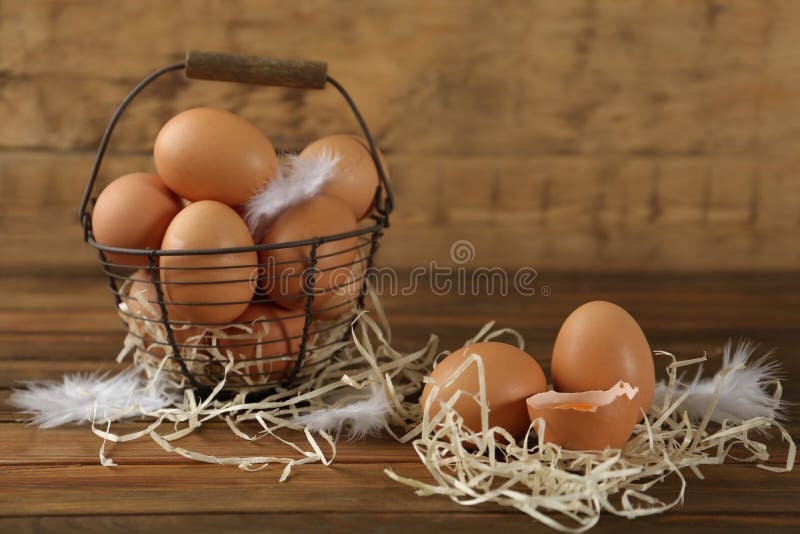 Raw chicken eggs, decorative straw and feathers royalty free stock photo