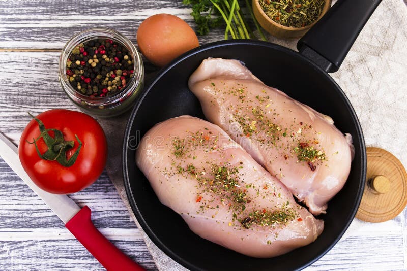 Raw chicken fillet with spices stock photo Raw chicken fillet with spices stock photo