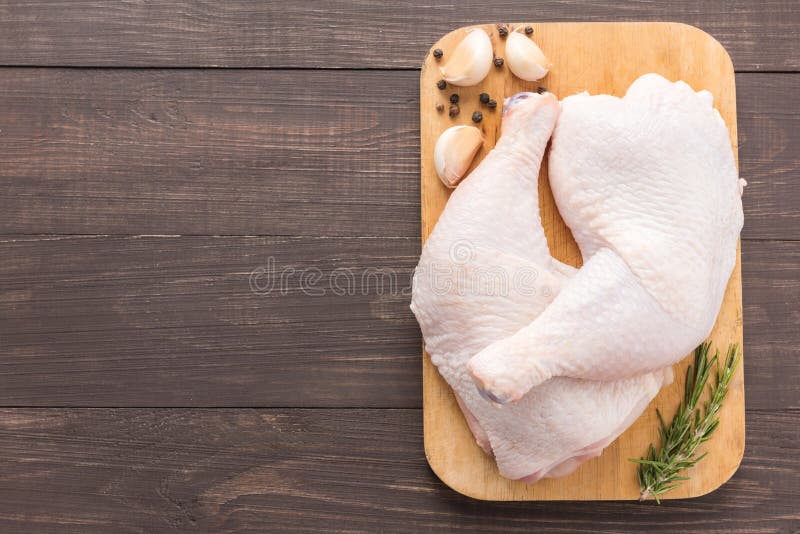 Raw Chicken Leg on Cutting Board on Wooden Background Stock Photo