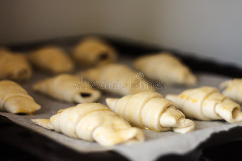 Raw Croissants with Chocolate on a Baking Sheet before Baking Stock