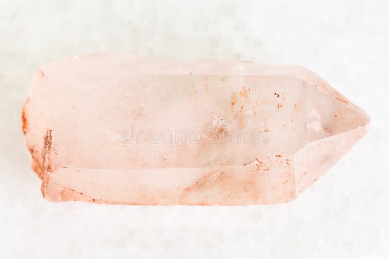 macro shooting of natural mineral rock specimen - raw crystal of rose quartz gemstone on white marble background from Aldan, Yakutia, Russia