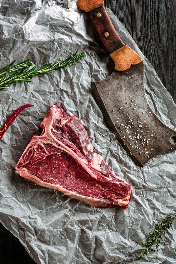Raw Dry Aged Tbone Steaks for Grill with Fresh Herbs and Cleaver Stock