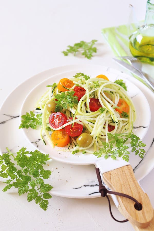 Raw food diet: salad with spaghetti of uncooked zucchini and cherry tomatoes