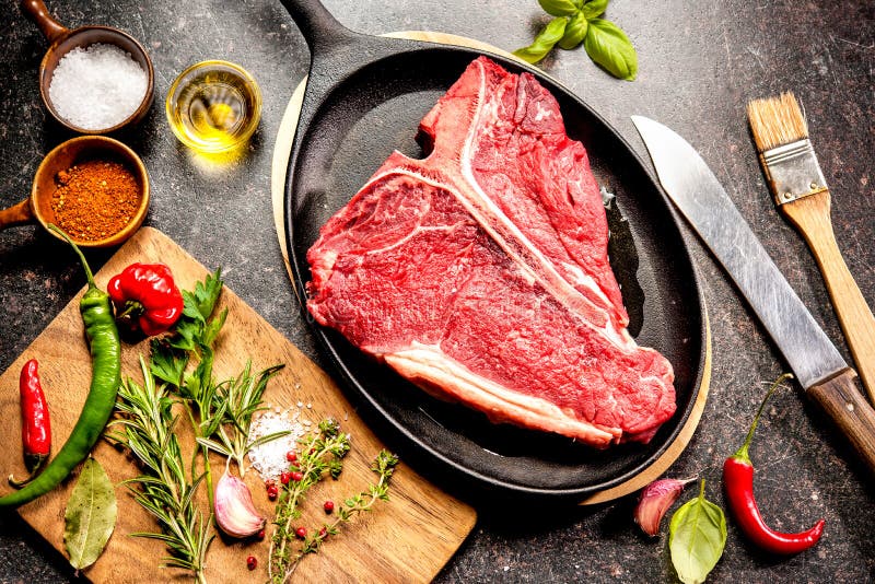 Raw Fresh Meat TBone Steak with Salt and Pepper on Wooden Background