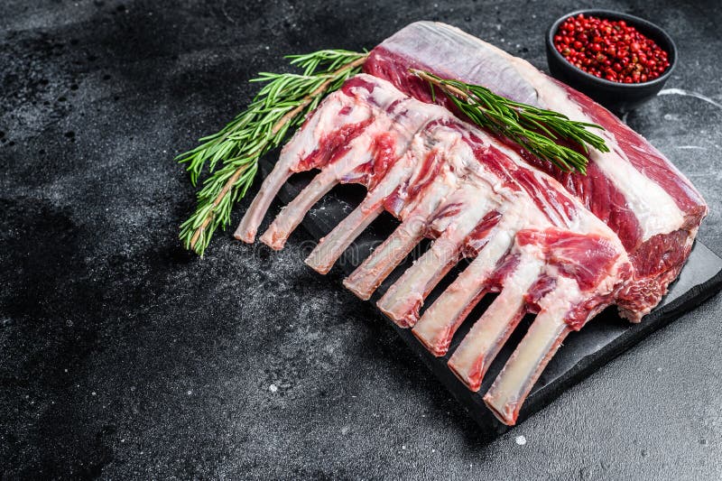 Raw Fresh Rack of Lamb Meat on Marble Board. Black Background. Top View