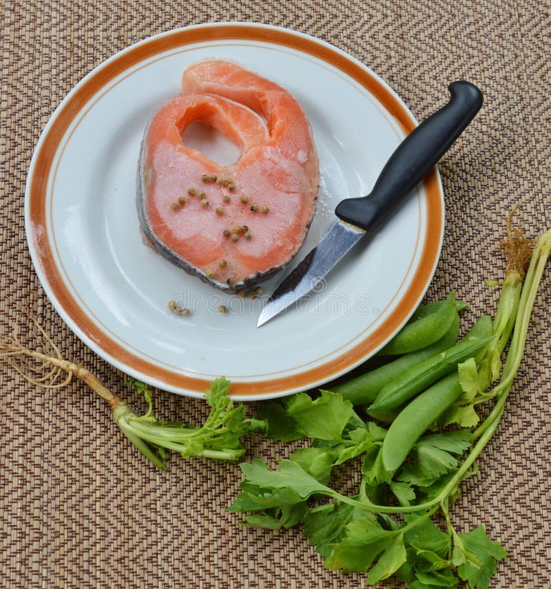 Raw Frozen Salmon Dressing Pepper and Knife on Bamboo Mat Stock Photo