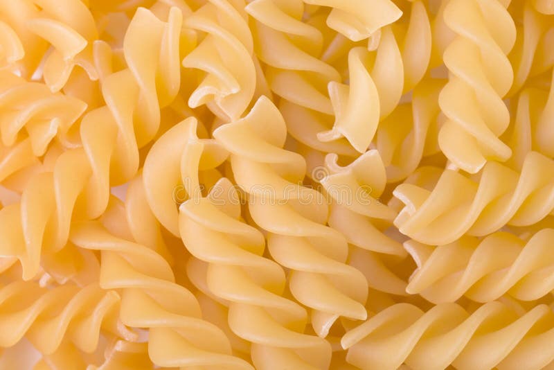 Raw fusilli pasta uncooked closeup. Food background