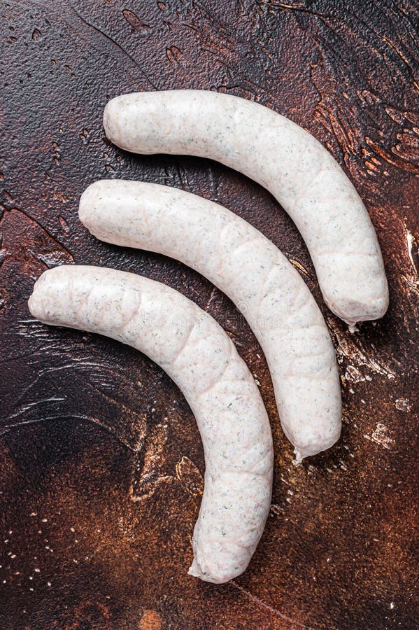 Raw German White Sausage Weisswurst on Kitchen Table. Dark Background