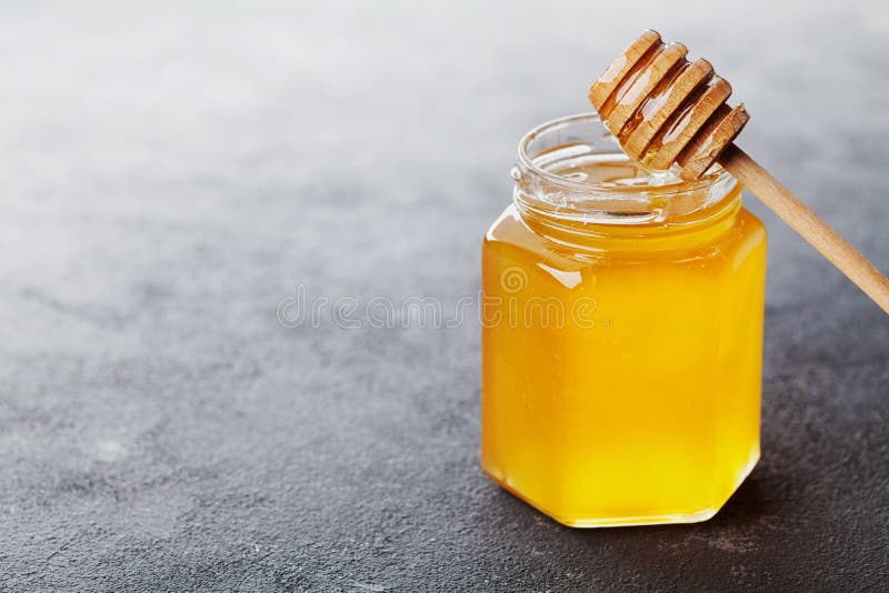 Raw honey in a jar on black table