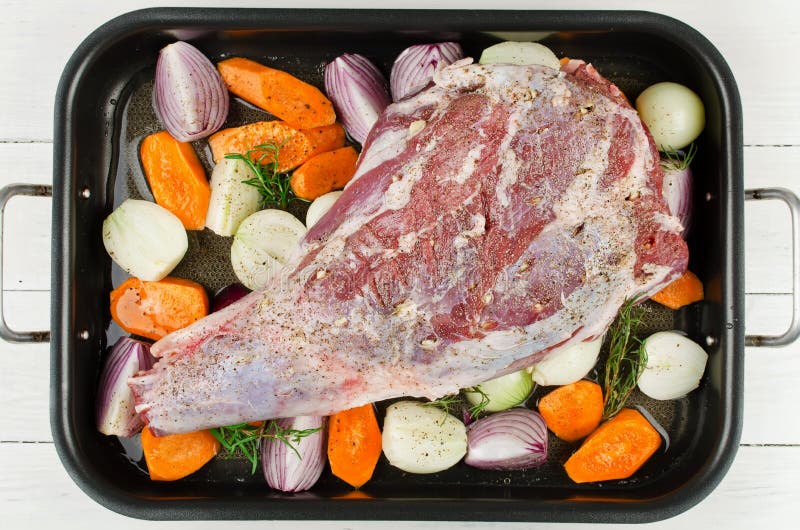 Raw leg of lamb with vegetables before roasted stock photos Raw leg of lamb with vegetables before roasted stock photos