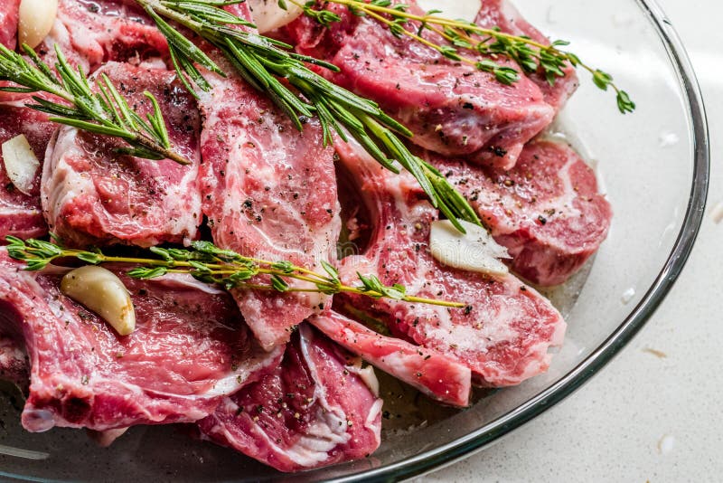 Raw Marinated Lamb Chops with Rosemary, Olive Oil and Garlic in Glass