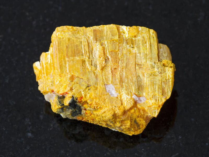 raw native orpiment stone on dark background stock images raw native orpiment stone on dark background stock images