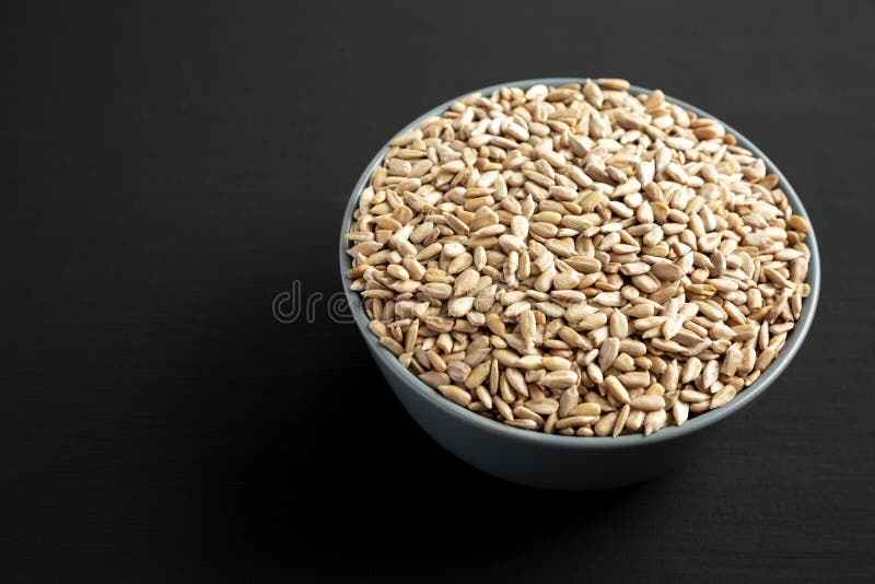 Raw Organic Sunflower Seed Kernels in a Blue Bowl, Side View. Space for