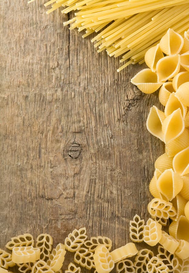 Raw pasta on wood background