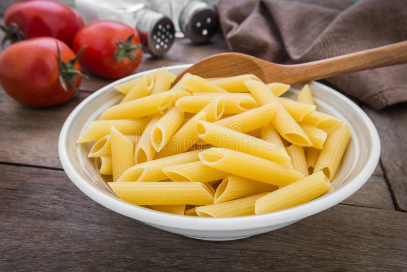 Raw Penne Pasta in Wooden Bowl Stock Photo Image of mats, heap 53728722