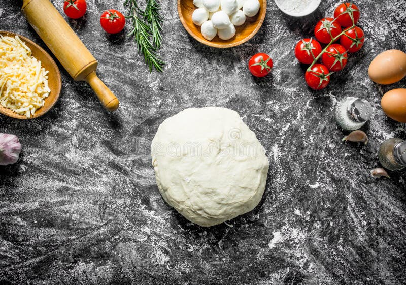 Raw pizza. Dough with different ingredients for cooking homemade pizza stock photography Raw pizza. Dough with different ingredients for cooking homemade pizza stock photography