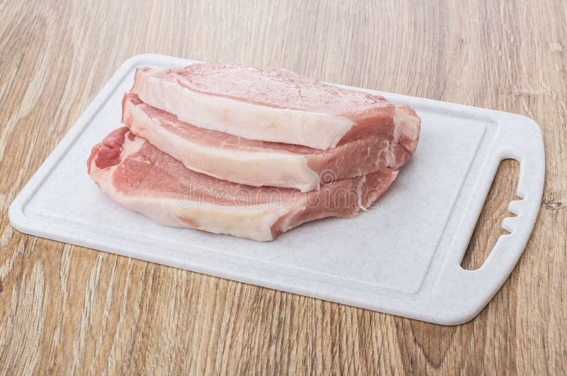Raw Pork Cutlets on Plastic Cutting Board on Table Stock Image Image