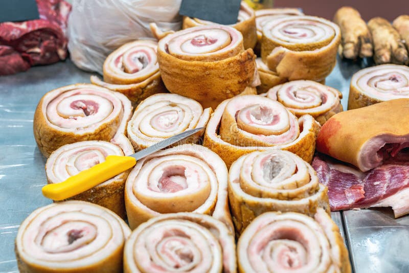 Raw pork fat rolls at market counter. Fresh lard at local farmer market fair.