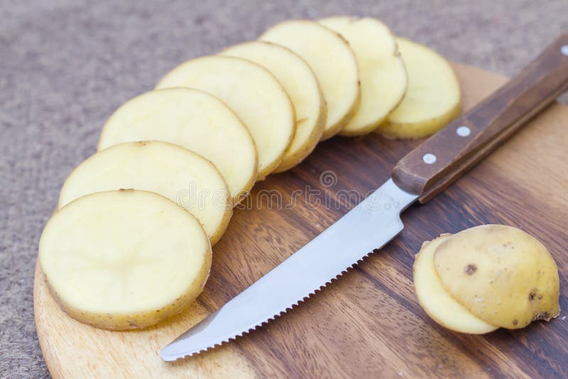 Raw potato slices. Raw potato slices the wooden floor background royalty free stock photography