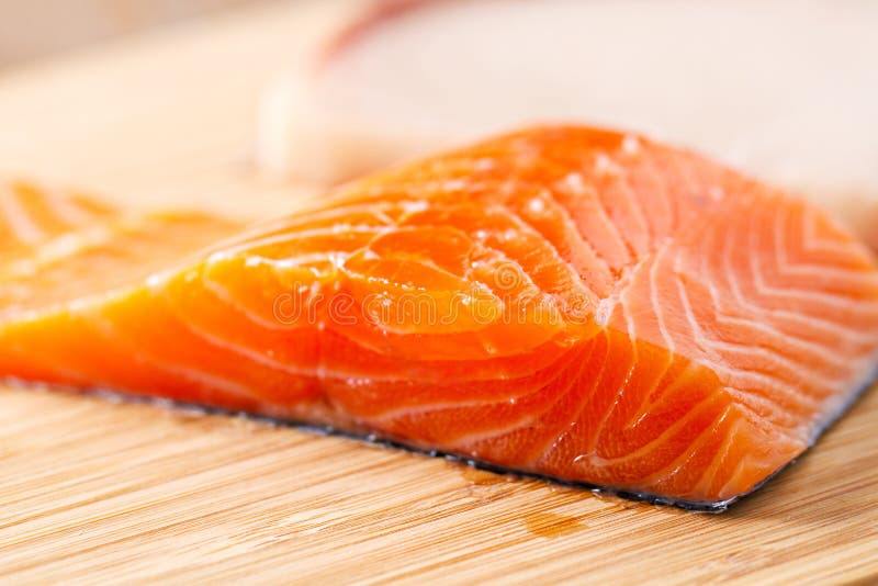 Raw salmon fillet on a cutting board. royalty free stock images