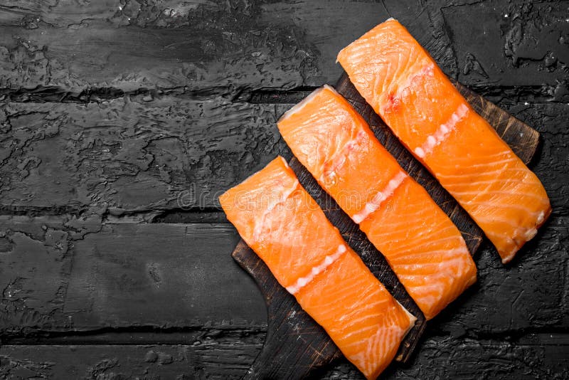 Raw salmon fish filet on cutting Board