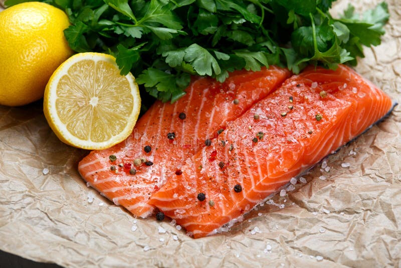 Raw Salmon fish fillet with fresh herbs on crumpled paper